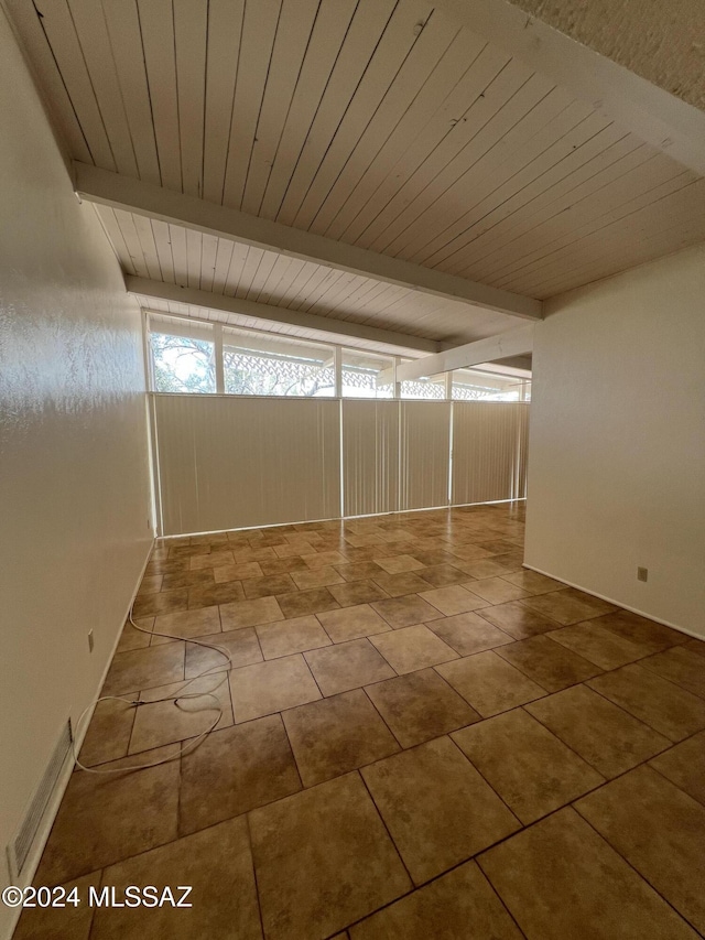 interior space featuring tile patterned floors, beamed ceiling, and wooden ceiling