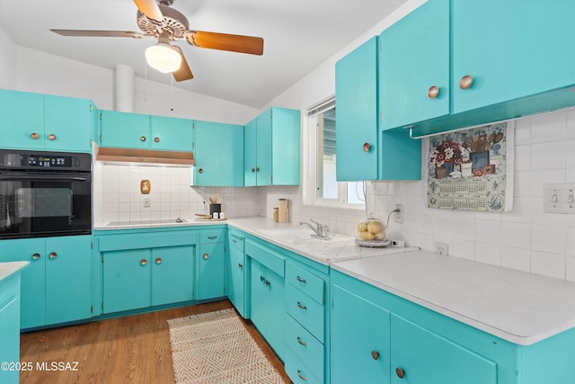 kitchen featuring blue cabinetry, dark hardwood / wood-style flooring, tasteful backsplash, and black appliances