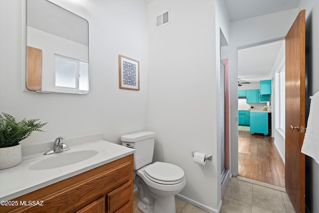 bathroom with ceiling fan, tile patterned floors, an enclosed shower, toilet, and vanity