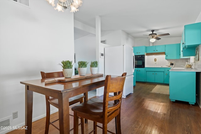 dining space featuring dark hardwood / wood-style floors and ceiling fan with notable chandelier