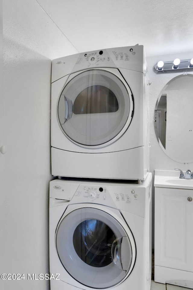 laundry room featuring stacked washer / dryer and sink