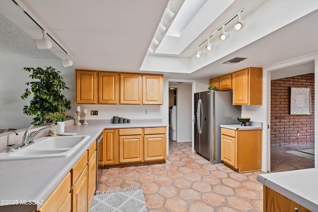 kitchen with stainless steel refrigerator with ice dispenser, sink, and light tile patterned flooring