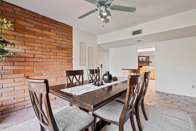 tiled dining space featuring ceiling fan and a textured ceiling