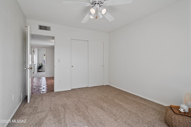 unfurnished bedroom with carpet floors, a closet, and ceiling fan