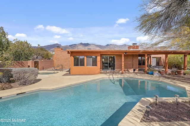 view of swimming pool featuring a patio and a mountain view