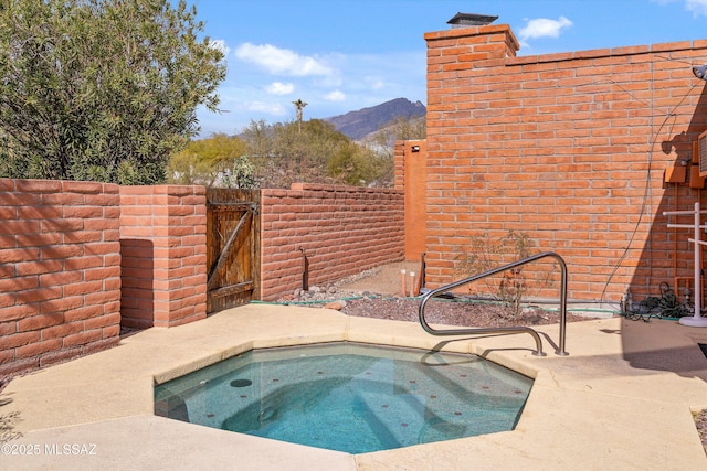 view of swimming pool featuring an in ground hot tub and a mountain view