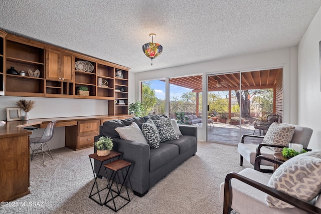 carpeted living room with built in desk and a textured ceiling