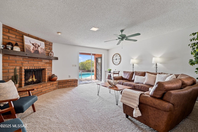 living room featuring ceiling fan, carpet flooring, a fireplace, and a textured ceiling