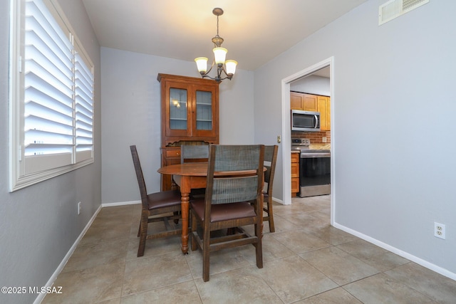 tiled dining area featuring a notable chandelier