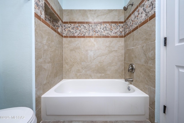 bathroom with tiled shower / bath combo and toilet