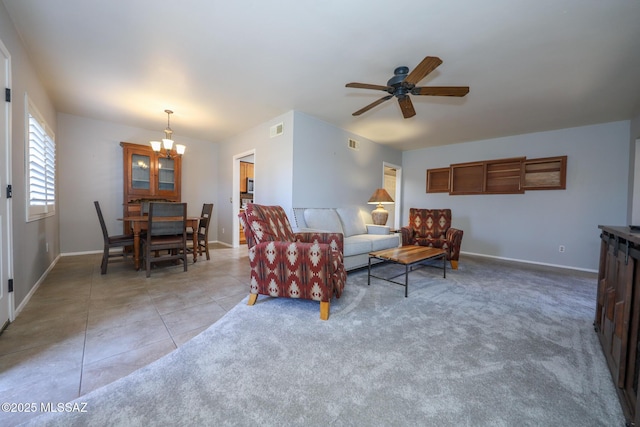 living room featuring ceiling fan with notable chandelier and light tile patterned floors