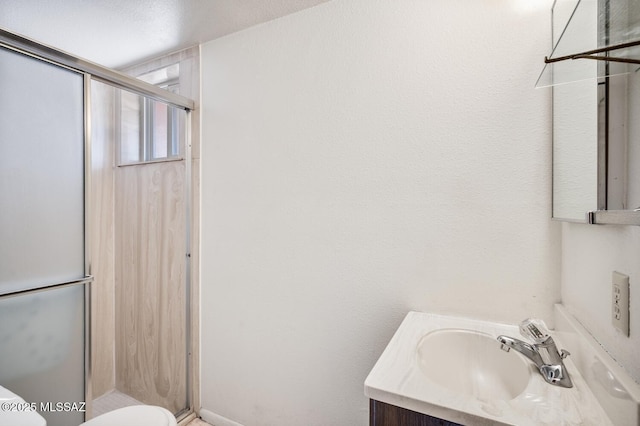 bathroom featuring walk in shower, vanity, and toilet