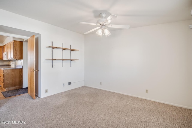 empty room with light colored carpet and ceiling fan