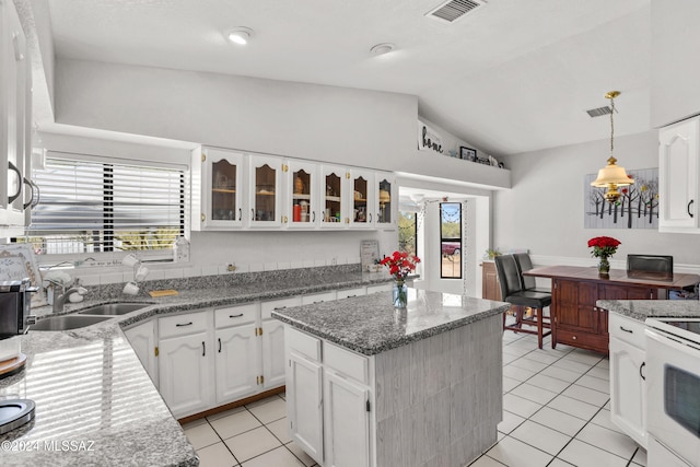 kitchen featuring a center island, sink, decorative light fixtures, lofted ceiling, and white cabinets