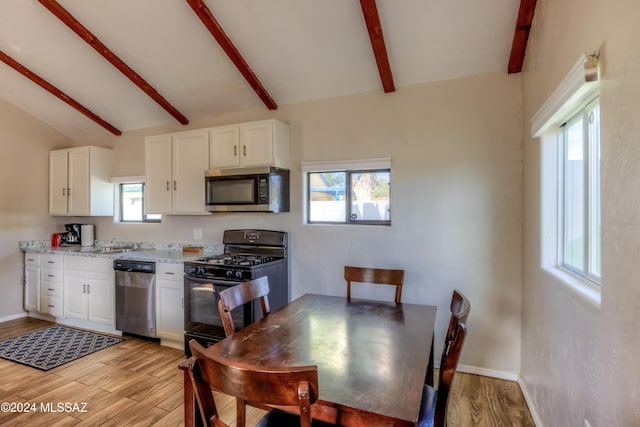 kitchen with white cabinets, appliances with stainless steel finishes, and light hardwood / wood-style flooring