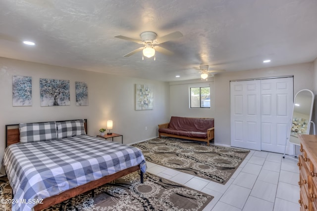 tiled bedroom featuring ceiling fan and a closet