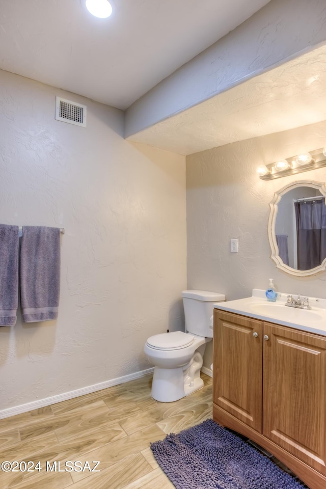 bathroom featuring hardwood / wood-style flooring, vanity, and toilet