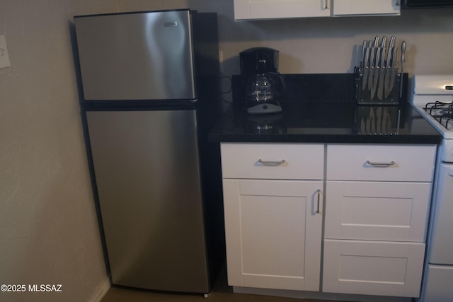 kitchen with stainless steel fridge, gas range gas stove, and white cabinets