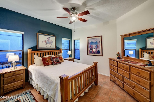 tiled bedroom with ceiling fan and a textured ceiling