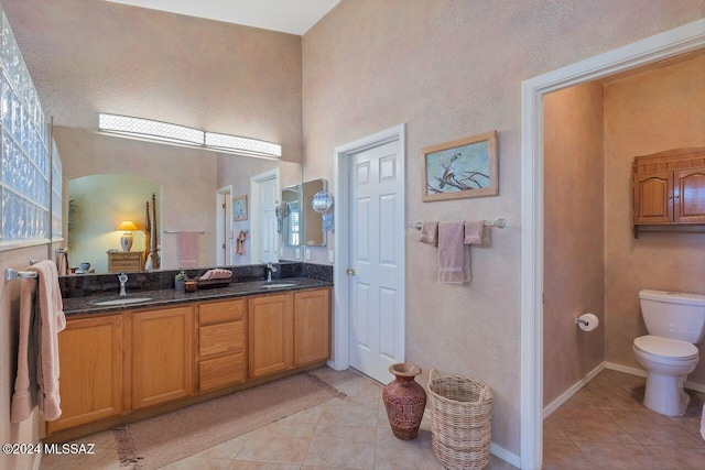 bathroom featuring tile patterned flooring, vanity, and toilet