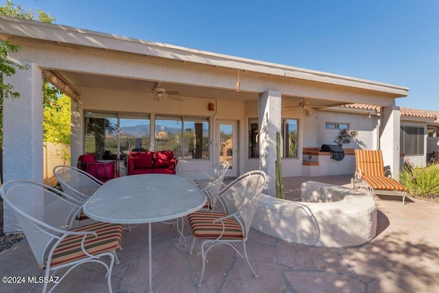 rear view of house with ceiling fan, a patio area, and exterior kitchen