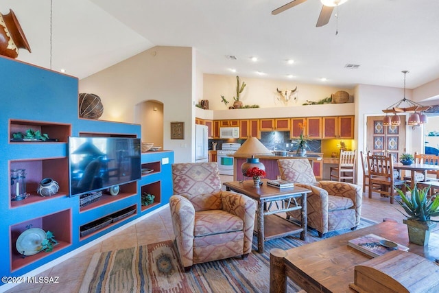 tiled living room with ceiling fan and high vaulted ceiling