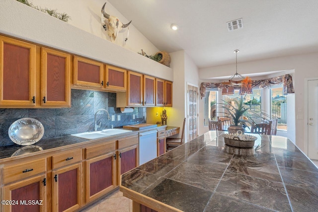 kitchen with dishwasher, sink, high vaulted ceiling, decorative light fixtures, and decorative backsplash