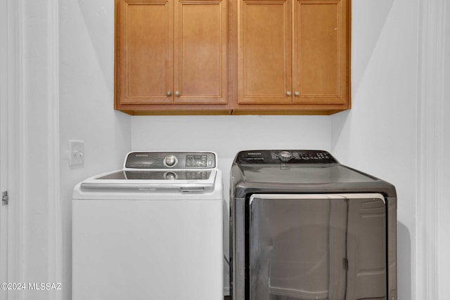 laundry room with cabinets and separate washer and dryer