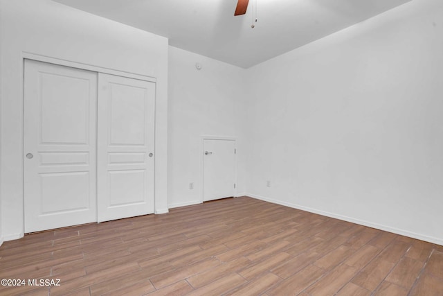 unfurnished bedroom with light wood-type flooring, a closet, and ceiling fan