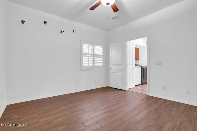 unfurnished room featuring hardwood / wood-style floors, washer / clothes dryer, and ceiling fan