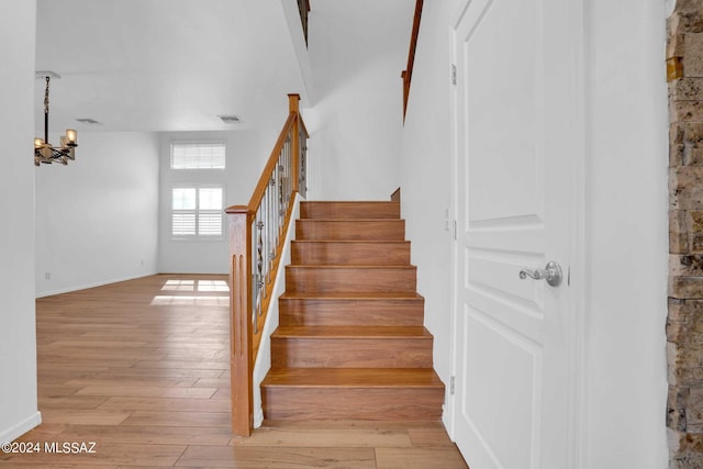 stairway featuring a chandelier and hardwood / wood-style floors