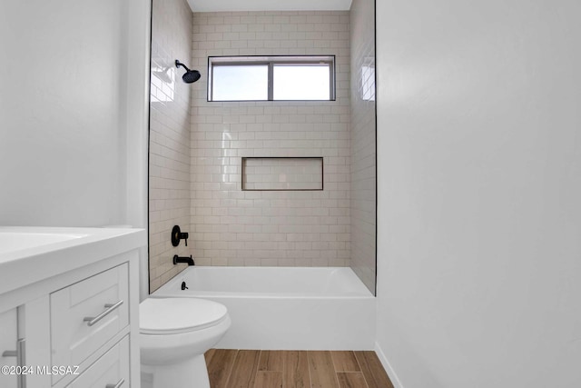 full bathroom with hardwood / wood-style flooring, vanity, toilet, and tiled shower / bath