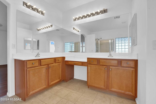 bathroom with tile patterned floors, vanity, and walk in shower