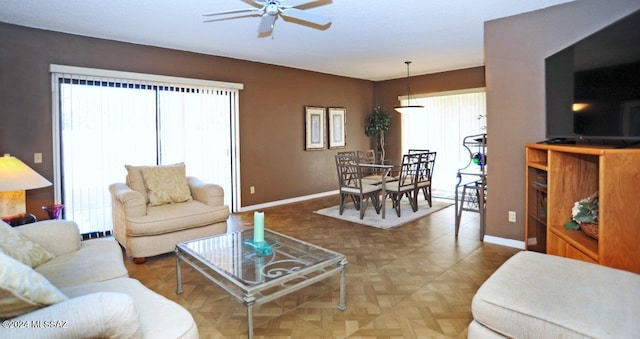 living room with plenty of natural light, ceiling fan, and parquet floors