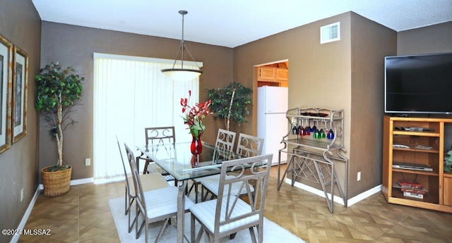 dining space featuring parquet flooring