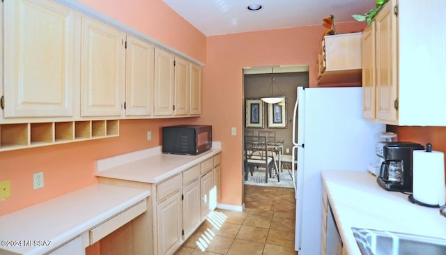 kitchen with light tile patterned floors and white fridge