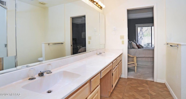 bathroom featuring vanity, toilet, and parquet floors