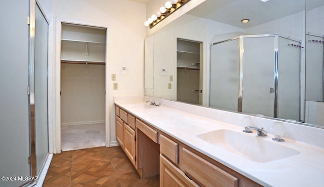 bathroom featuring vanity, an enclosed shower, and parquet flooring