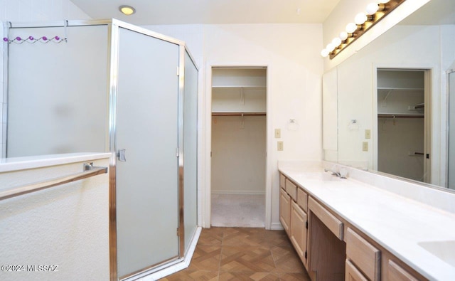 bathroom with parquet flooring, vanity, and a shower with door