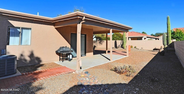 back of property with central air condition unit and a patio