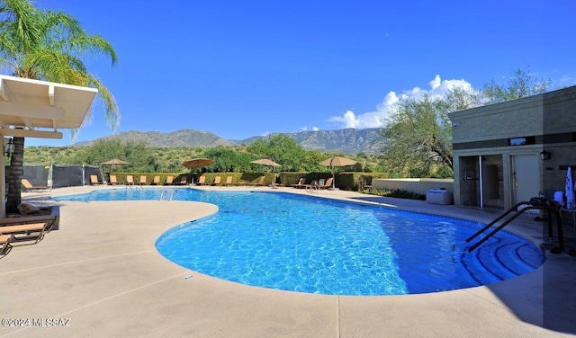 view of swimming pool with a patio area and a mountain view