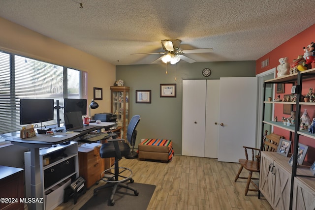 office space featuring a textured ceiling, light hardwood / wood-style flooring, and ceiling fan