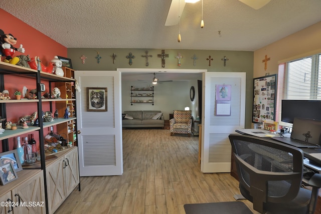 office with a textured ceiling, light hardwood / wood-style floors, and ceiling fan