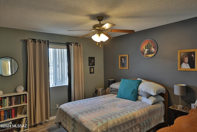 bedroom featuring wood-type flooring, a textured ceiling, and ceiling fan