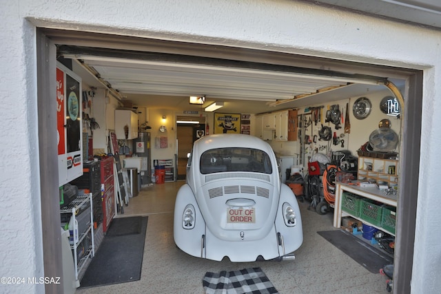 garage featuring a workshop area and water heater