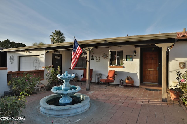 view of exterior entry with a patio