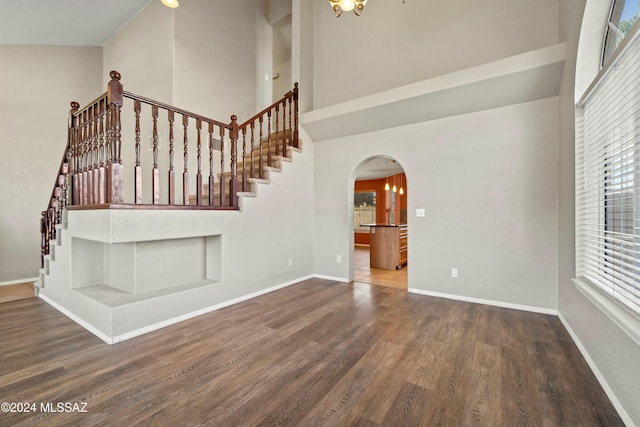 staircase featuring hardwood / wood-style flooring and a towering ceiling