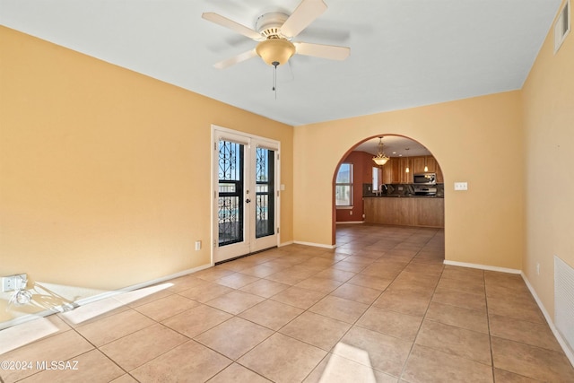 spare room featuring light tile patterned floors, ceiling fan, and french doors