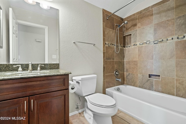 full bathroom with vanity, tiled shower / bath, vaulted ceiling, tile patterned floors, and toilet