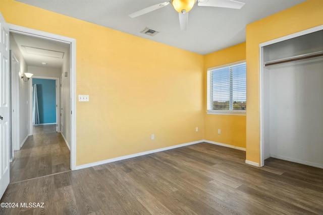 unfurnished bedroom with dark hardwood / wood-style floors, a closet, and ceiling fan